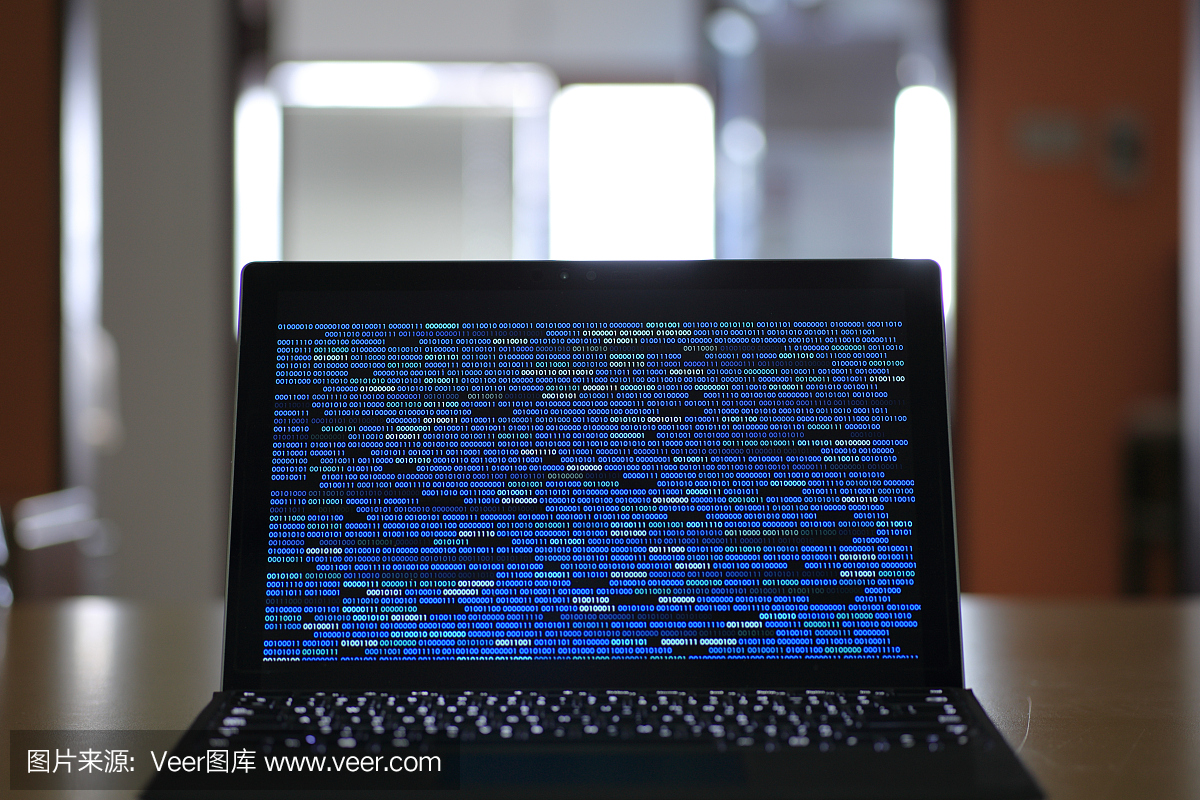 计算机开发人员和数据黑客。桌上的笔记本电脑,屏幕上显示二进制计算机代码。互联网隐私与网络安全。
